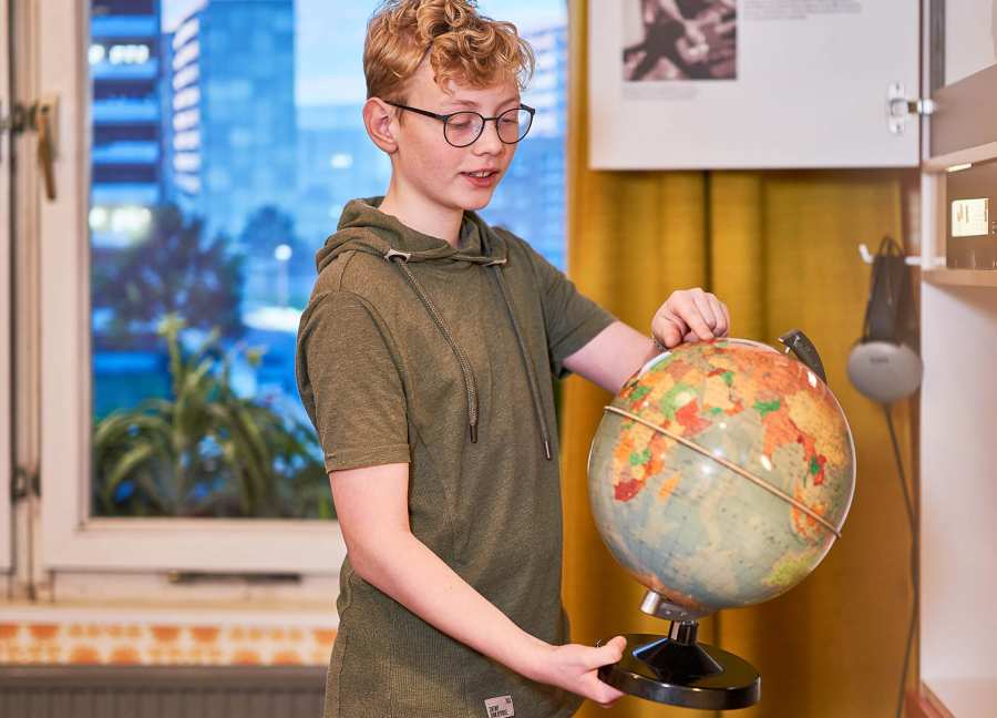 Boy with globe in the children's room at the DDR Museum