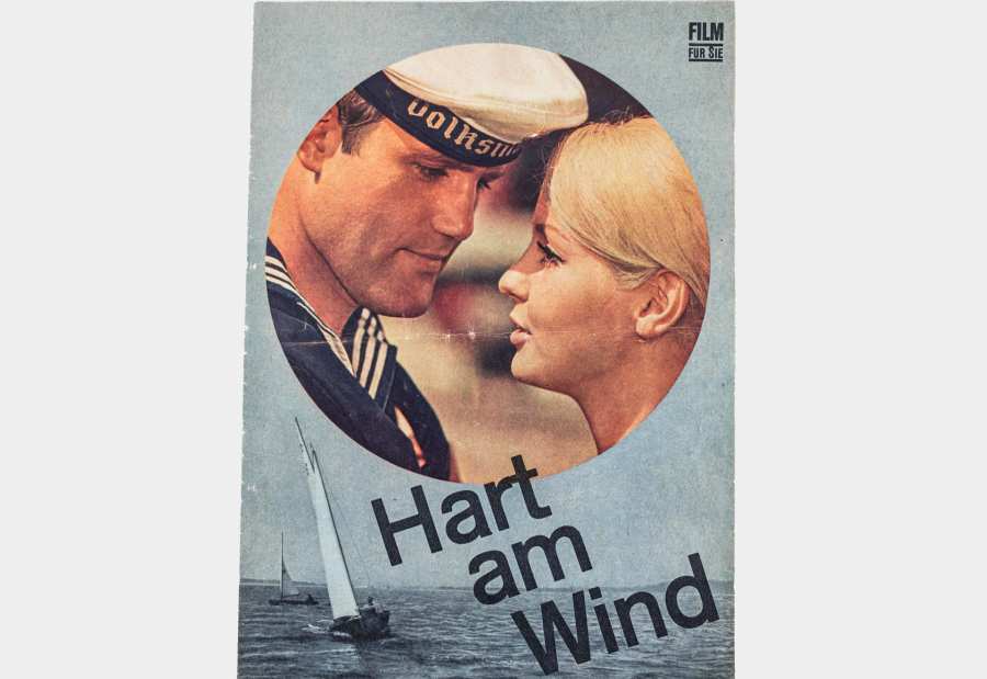 Filmbegleitheft »Hart am Wind«. Vordergrund: eine Frau und ein Mann, im Hintergrund Boote auf dem Meer. 